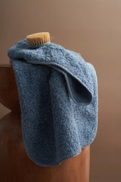 Blue bath towel draped on a pedestal, home textile product photography by Southlake Vision in China.