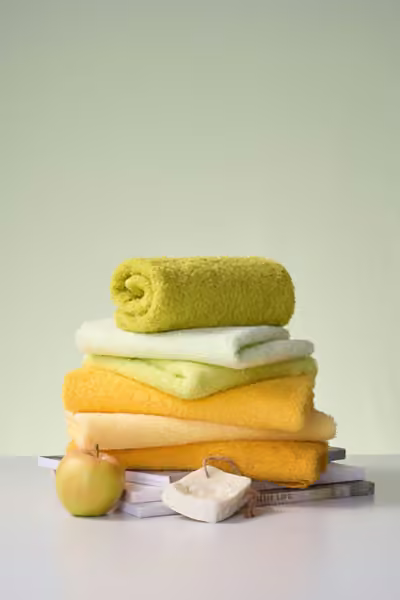 Bright towel collection on a green backdrop, home textile product photography by Southlake Vision in China.