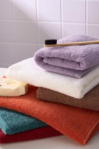 Layered towels in a tiled bathroom, home textile product photography by Southlake Vision in China.