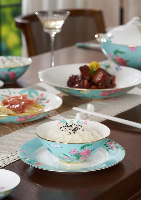 Coordinated floral ceramic plates and bowls arranged for a meal at the dining table.